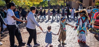 People of different ages holding hands, walking in circle at NJ Center for Indigenous Justice Welcome ceremony