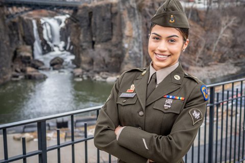 Brianna Correa, wearing her National Guard Army Green Service Uniform, modeled after WWII-era attire, at the Paterson Great Falls, reflecting her strong connection to her hometown city.