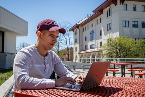 Person sitting with a laptop outdoors