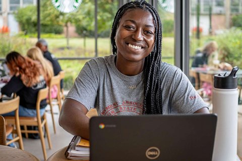 Woman smiling in front of a computer. 