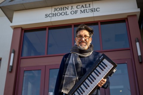 Bob Bailey-Lemanskyholds a keyboard outside the Cali School of Music.
