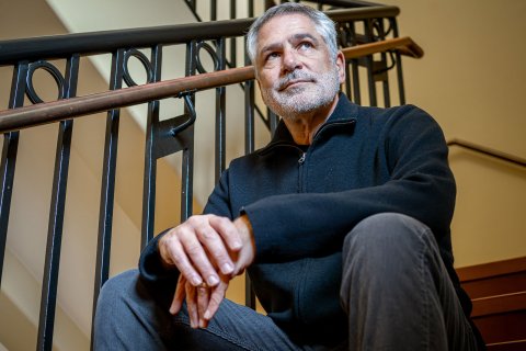 Professor Jon Caspit sits on steps.