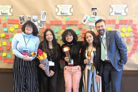 Four students alongside a professor posing after presenting at the NRHC conference.