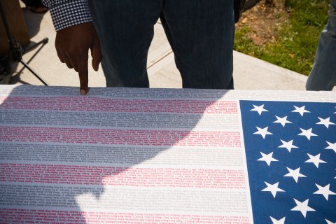 poster of American flag where the strips are made from the names of lives lost on september 11