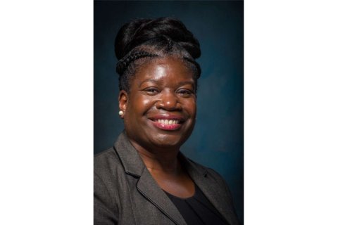 Woman is smiling directly into the camera. 