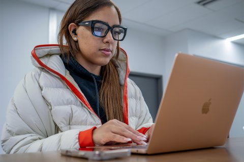 A college student sits at her computer.