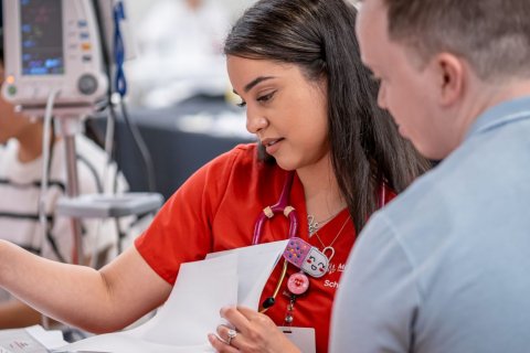 Nurse looking over papers with someone else.