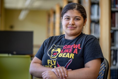 Odyeli Ramos Tobar sits at a table in the campus library.