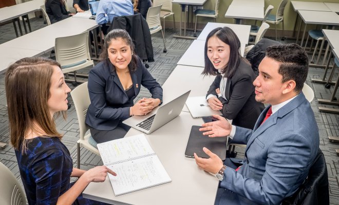 Students in business attire gathered at a table