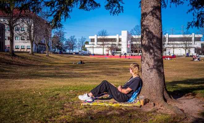 Student on the campus quad, looking away from camera (face not visible)