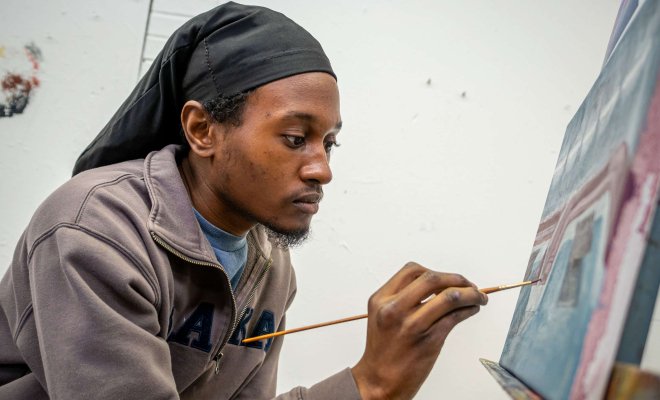 Student painting on canvas.