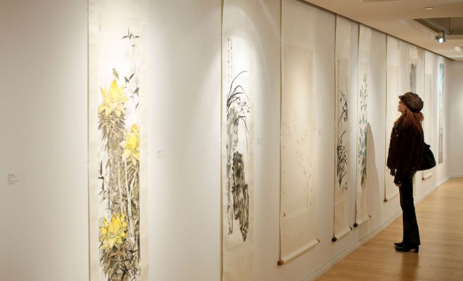 Person in gallery viewing Chinese art.