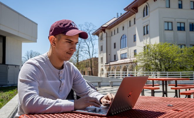 Person sitting with a laptop outdoors