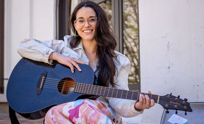 Alyssa Muñiz holds a guitar.