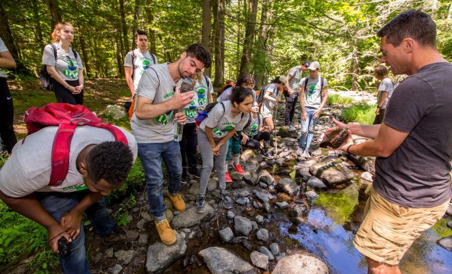 Montclair CSAM students conducting field studies near a stream.