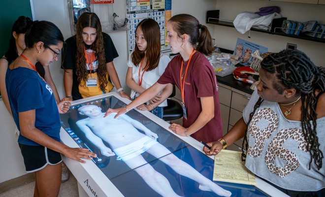 Pre teens examining a diagram of a body.