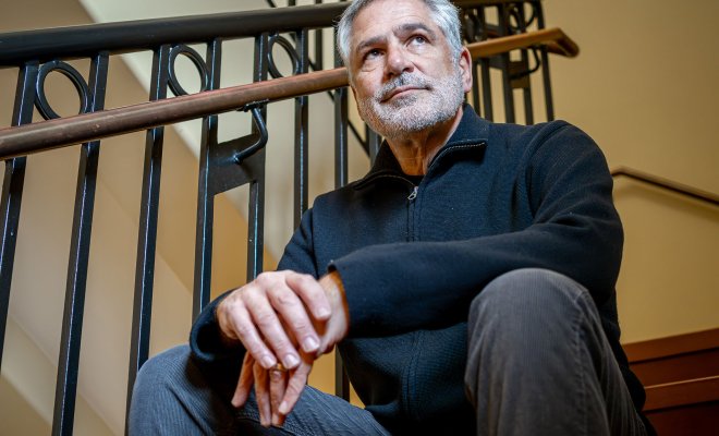 Professor Jon Caspit sits on steps.
