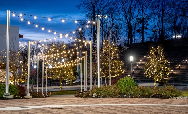 Campus at night with fairy lights overhead.