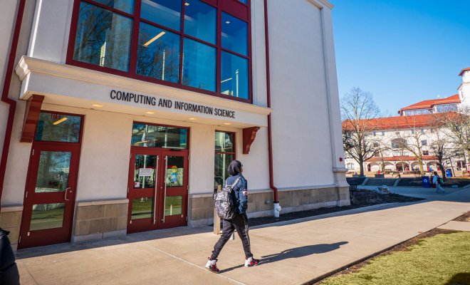 Student walking past the entrance of the Center for Computing and Information Science