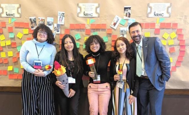 Four students alongside a professor posing after presenting at the NRHC conference.