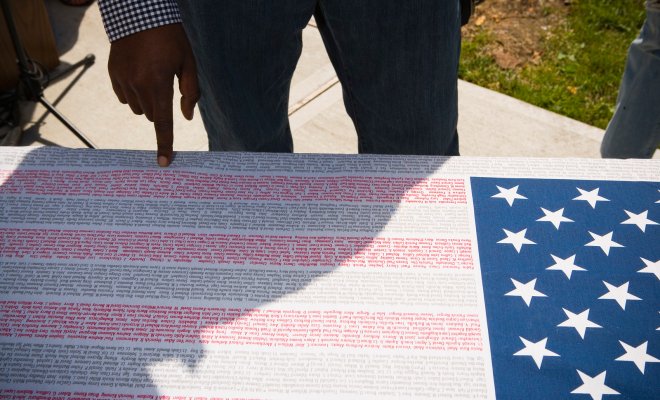 poster of American flag where the strips are made from the names of lives lost on september 11