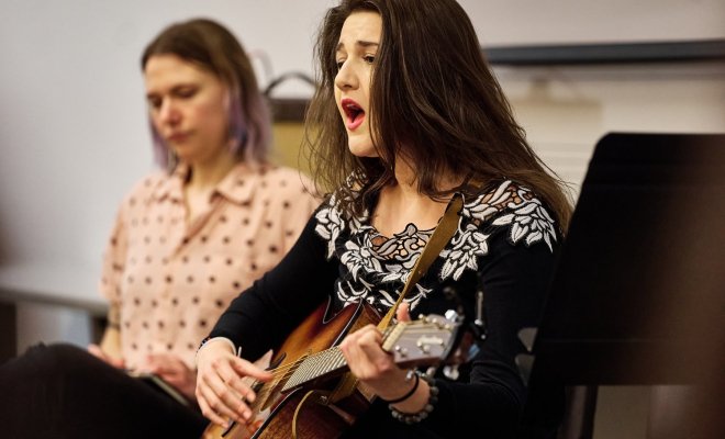 A Music Therapy student sings and plays guitar.
