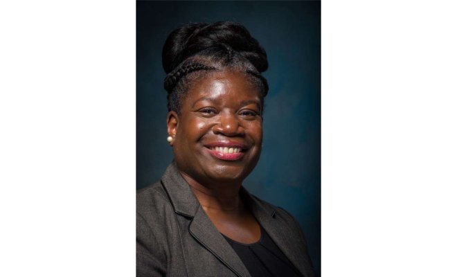 Woman is smiling directly into the camera. 