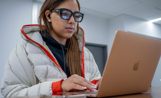 A college student sits at her computer.