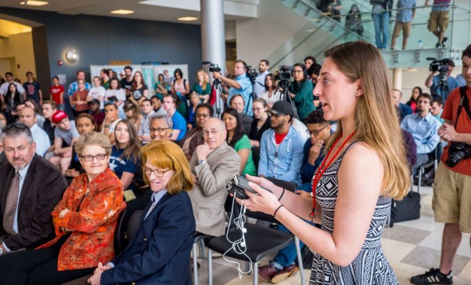 A student asks a question during a press conference at Montclair State University