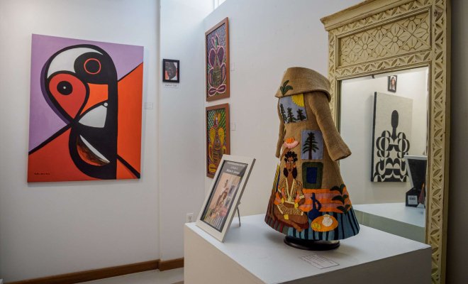 An art gallery exhibition featuring paintings and sculptures with an African influence