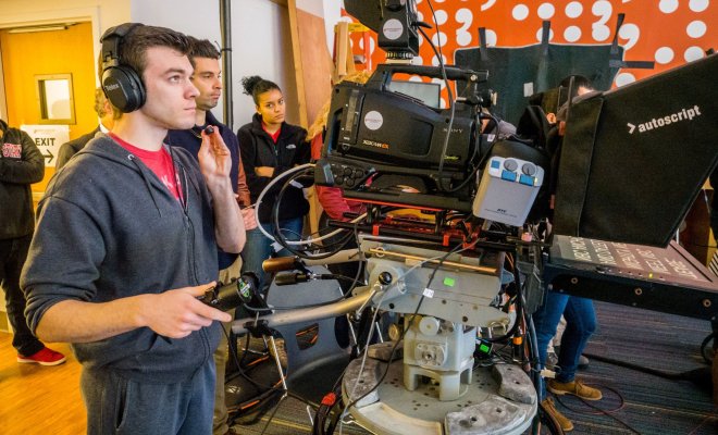 A student films a television broadcast at Montclair State University.