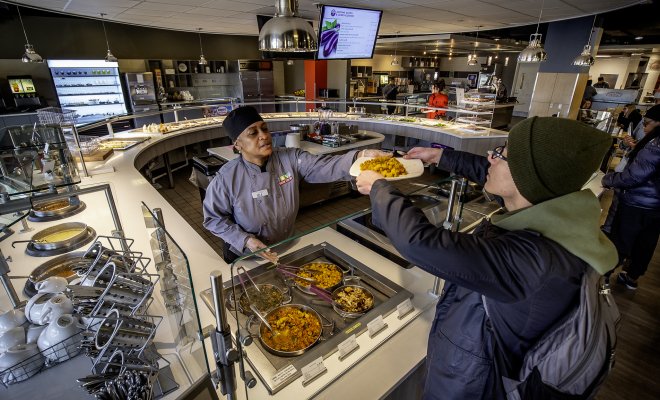 Student receiving food at Sams Place over the counter. 