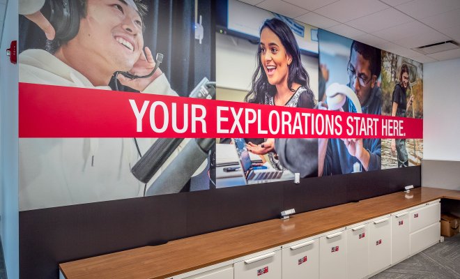 Poster with the text "Your explorations start here" with students in the background of the poster.