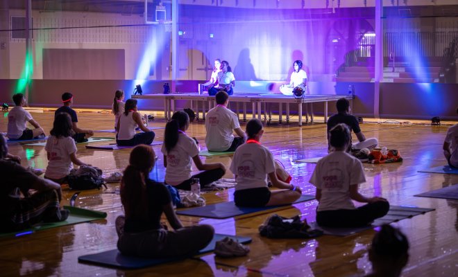 Glow yoga studio filled with students in poses.