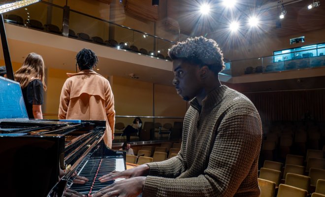 Cali student playing on a piano.