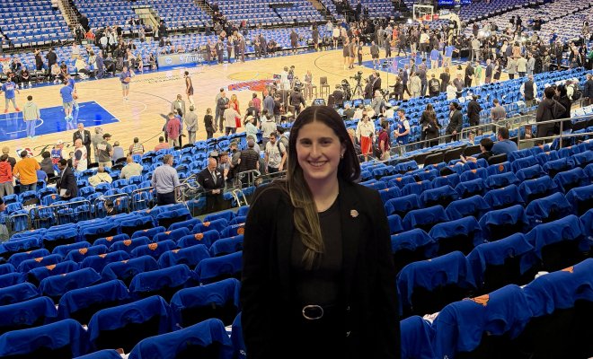 Emily Swedelson standing in the stands at Madison Square Garden with the court in the background.