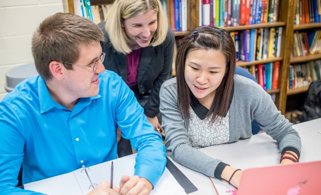 Two students in discussion with instructor