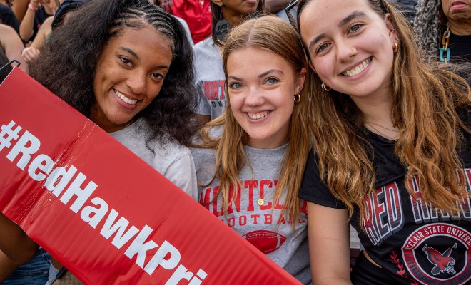 Students wearing Montclair tees, holding a Red Hawk Pride sign
