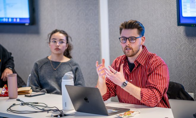 Strategic communication student leading discussion on laptop
