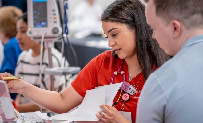 Healthcare professional analyzing clinical data and health records in a professional training environment at Montclair State University.
