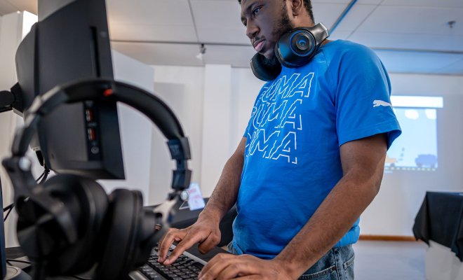 Student working on their computer with headphones on.