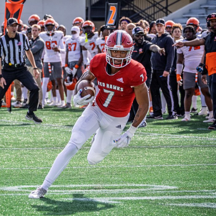 A football player charges down the field with the ball