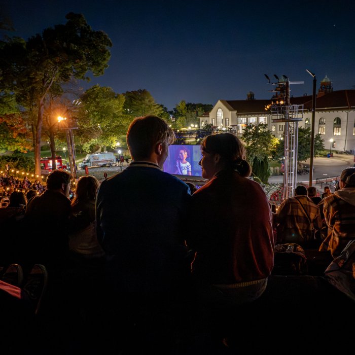 Students watch a movie outdoors in the amphitheater. 