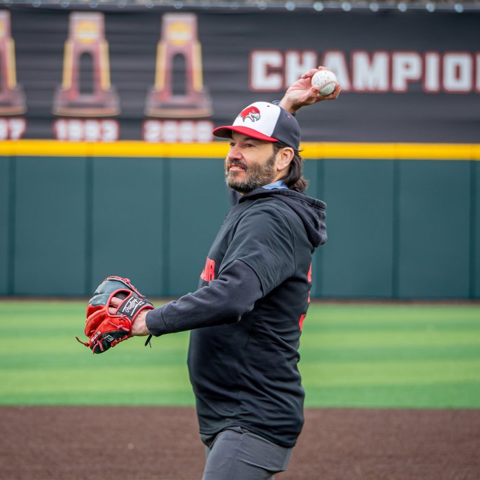 A man with a baseball mitt and cap as he pitches the ball..