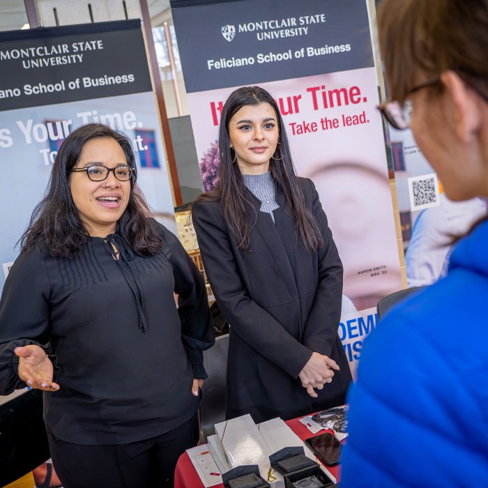 Two women speak to a student.
