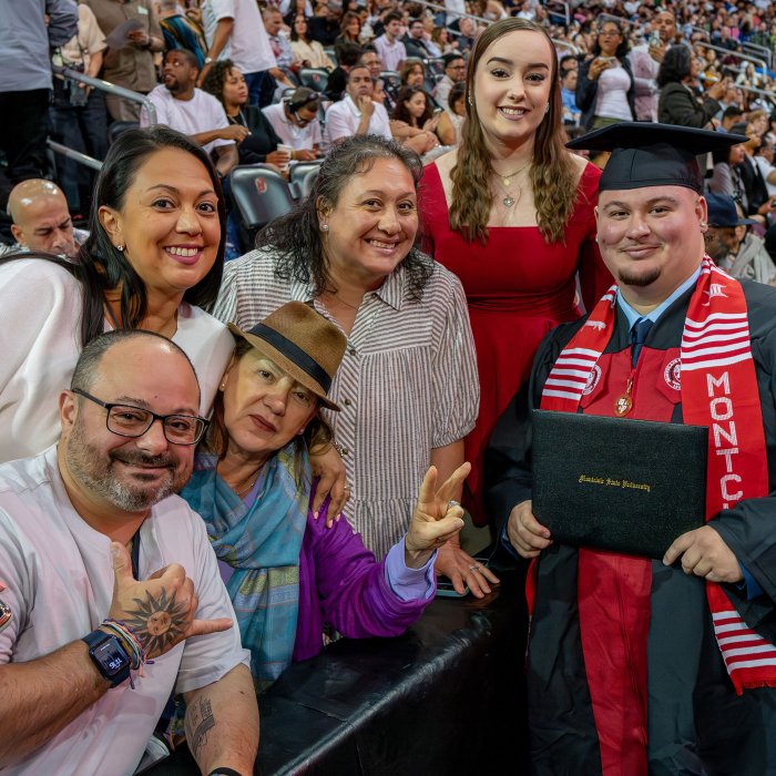 A family of five poses with their graduate inside Prudential Center
