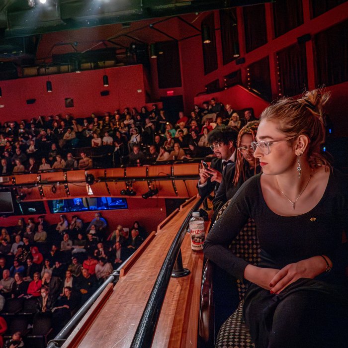  Audience members in a packed theater enjoy a concert.