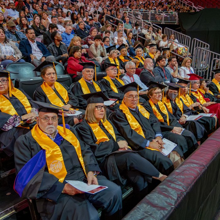 a group of alumni seated in caps and robes for the 50th anniversary of their graduation