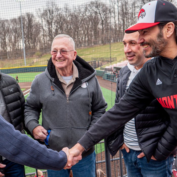 Men shake hands in the stands.