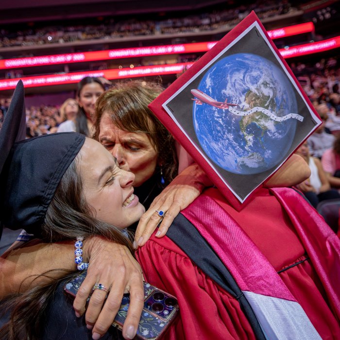 a family member hugging two graduates
